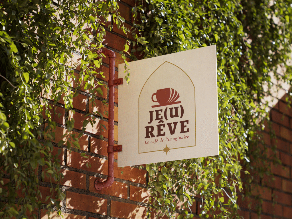 Enseigne du café Je(u) Rêve accrochée sur une façade végétalisée, à Brest. Lieu chaleureux dedié à l'univers de l'imaginaire, du jeux et café cosy