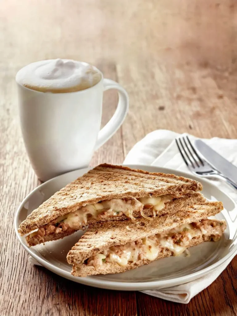 Sandwich grillé servi sur une assiette avec salade et boisson chaude, option déjeuner au café de l'imaginaire Je(u) Rêve à Brest