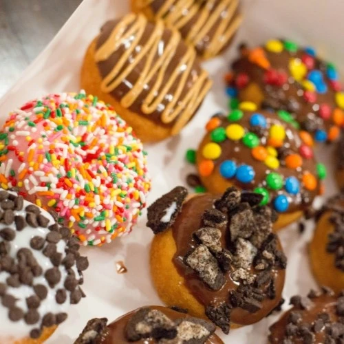 des donuts dans une boites avec des glacage multicolores