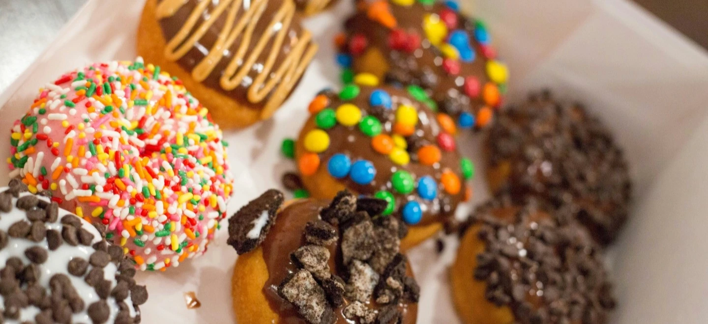 des donuts dans une boites avec des glacage multicolores
